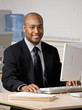 Happy businessman typing on computer at desk