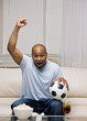 Excited man holding soccer ball cheering