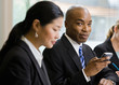 Businessman with co-workers holding phone in conference room