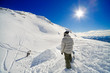 Snowboarders making / shaping a jump, deep blue sky