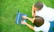 caucasian couple using laptop in park. love and family