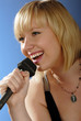 cute blond girl singing with microphone on stage cute blond girl singing with microphone on stage