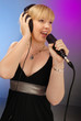cute blond girl singing with microphone on stage