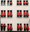 Windows with red window-shades on white wall