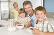 Photo : Father With Children As They Eat Breakfast And Mother In The Bac