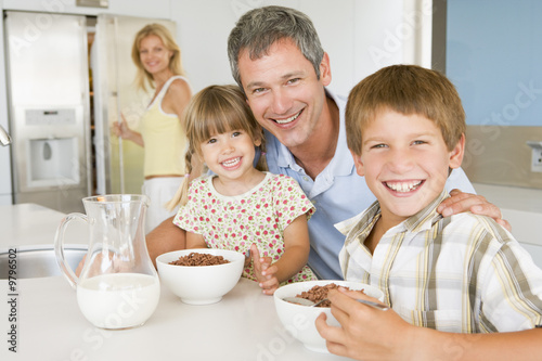 Photo: Father With Children As They Eat Breakfast And Mother In The Bac Father With Children As They Eat Breakfast And Mother In The Bac