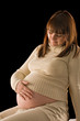 happy pregnant woman portrait on black background