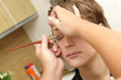 A cosmetologist applies eyeshadow for a woman
