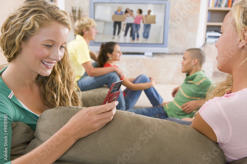 Photo: Teenagers Hanging Out In Front Of Television Using Mobile Phones Teenagers Hanging Out In Front Of Television Using Mobile Phones
