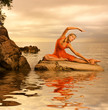 Beautiful young woman doing yoga exercise outdoors