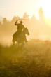 Cowboy silhouette galloping and roping through the desert