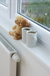 Photo: Two teddy bears sitting on radiator in home. Two teddy bears sitting on radiator in home.