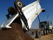 A large dump truck depositing its load at a construction site