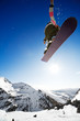 Snowboarder jumping through air with deep blue sky in background