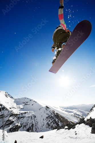 Foto: Snowboarder jumping through air with deep blue sky in background Snowboarder jumping through air with deep blue sky in background