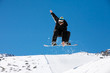 Snowboarder jumping through air on blue sky background