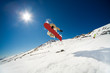 Snowboarder jumping through air on blue sky background