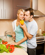 Young couple making vegetable salad in the kitchen
