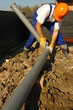 Plumber assembling pvc sewage pipes in house foundation