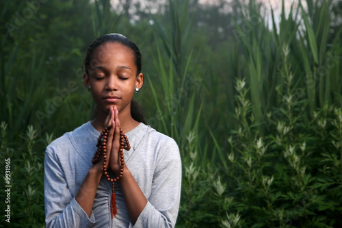 Photo: Teenage girl praying outdoors at twilight. Shallow DOF. Teenage girl praying outdoors at twilight. Shallow DOF.