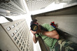 Photographer in New York City. Wide angle view from below.