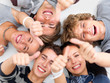 Happy young friends lying down showing thumbs up sign