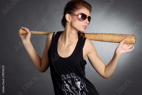 Foto: Beautiful girl holding a baseball bat, dark glasses Beautiful girl holding a baseball bat, dark glasses