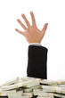 Close-up of businessman’s hand stuck out of dollar bills