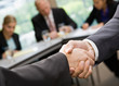 Photo: Close up of businessmen shaking hands in conference room Close up of businessmen shaking hands in conference room