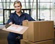 Delivery woman in uniform with stack of cardboard boxes