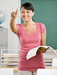 Happy teacher gesturing and asking questions in classroom