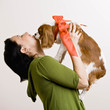 Devoted woman kissing pet dog with bow