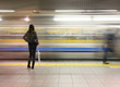 Lone woman watching subway speed by.
