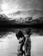 Man and woman are standing back to back in water