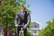 A caucasian businessman riding a bicycle to work