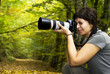 Young female photographer in forest Young female photographer in forest