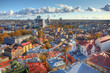 blue sky and white fluffy clouds over the autumn old town