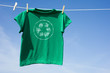 A green t-shirt hanging on a clothesline with the recycle symbol
