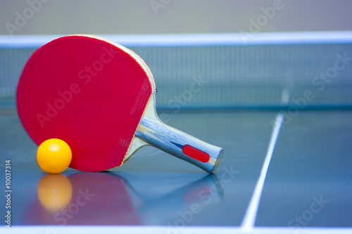Ping pong ball and racket lying in the corner of the table