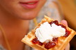 waffle with cream and  strawberry / plum jam on plate in hand