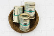 Rolls of twenty dollars bills sitting in nest on a puzzle