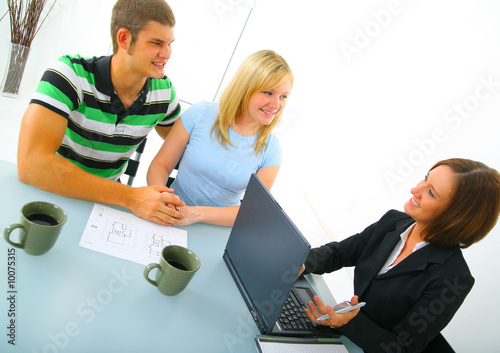 two caucasian couple talking with real estate broker