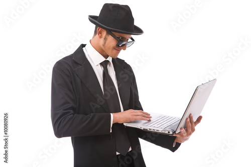 Photo: funny looking computer hacker with a laptop on white funny looking computer hacker with a laptop on white