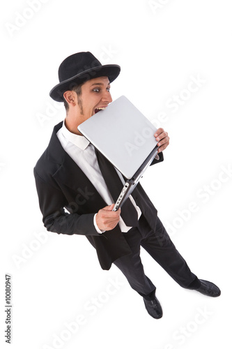Photo: funny looking computer hacker with a laptop on white funny looking computer hacker with a laptop on white