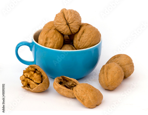 Photo: Walnuts in cup on white background Walnuts in cup on white background
