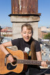 The girl with a guitar, singing on a roof