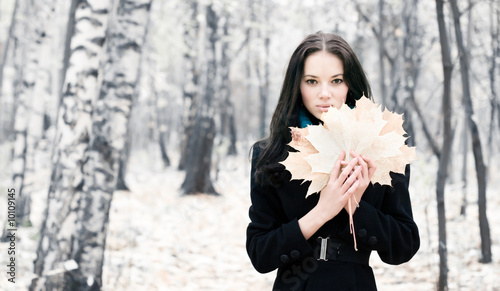 Photo: Brunette woman with maple leaves. Brunette woman with maple leaves.