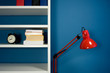 Photo: White bookcase with red reading lamp in blue room White bookcase with red reading lamp in blue room