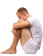 Melancholy young man in white. To sit having clasped knees.