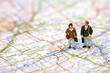 Miniature business travelers standing on a map.